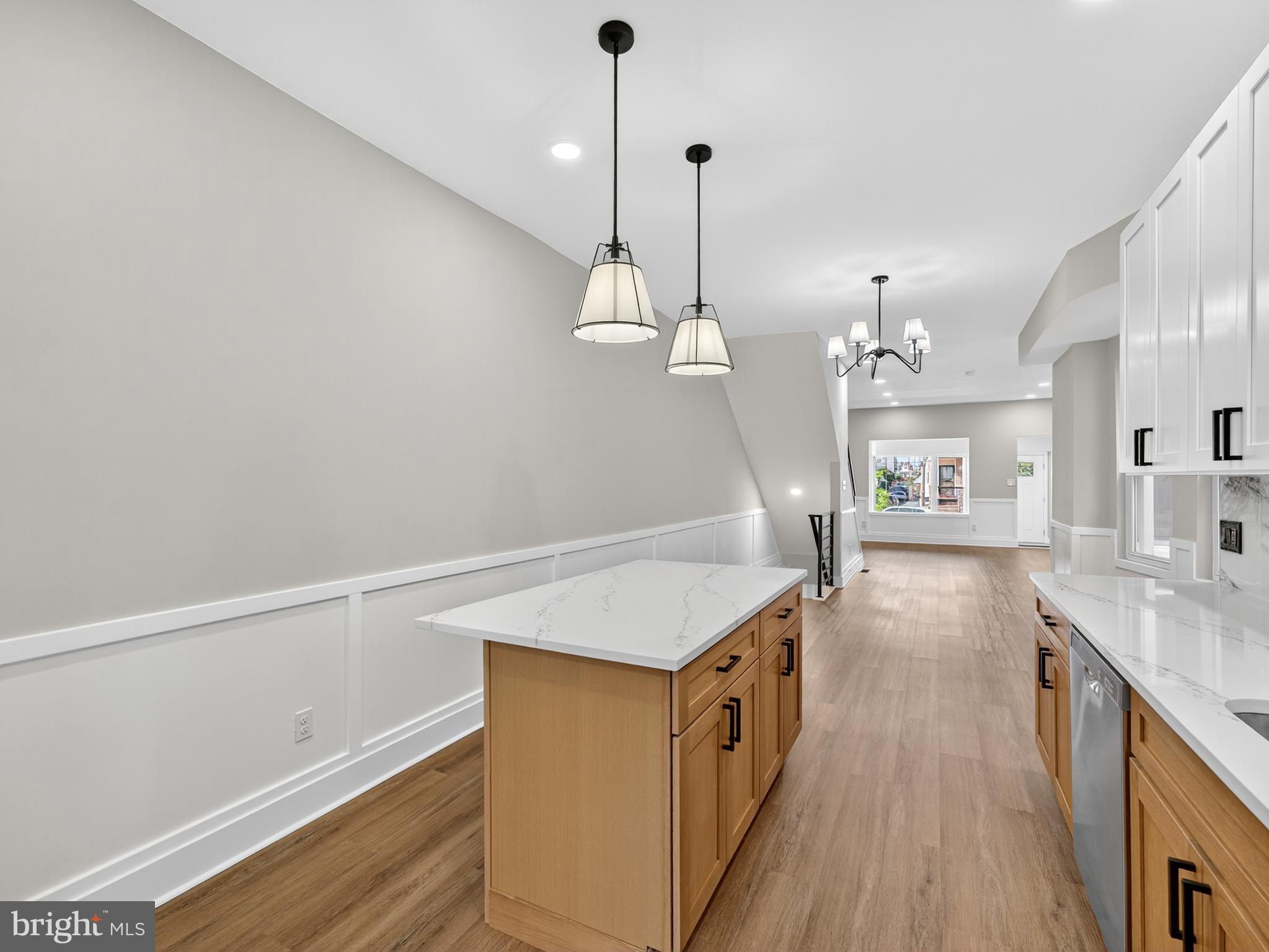 5736 Spruce Street Philadelphia, PA 19139 - Photo 6 of 32 a kitchen with granite countertop a stove a sink a center island and wooden floor