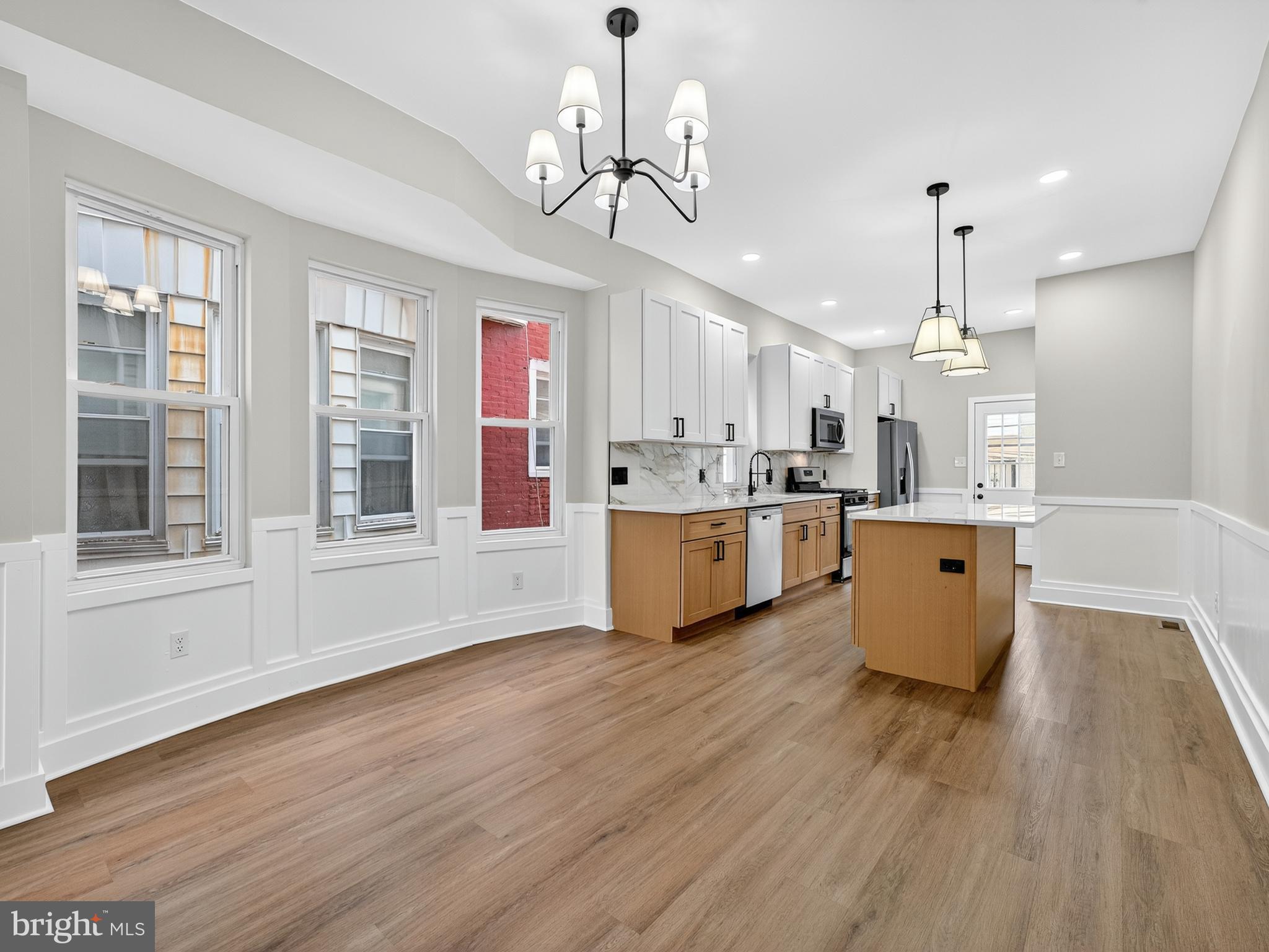 5736 Spruce Street Philadelphia, PA 19139 - Photo 7 of 32 a large kitchen with kitchen island granite countertop wooden floors and wide window