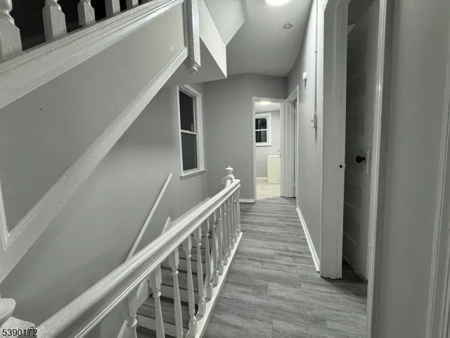 a view of a hallway with wooden floor and staircase