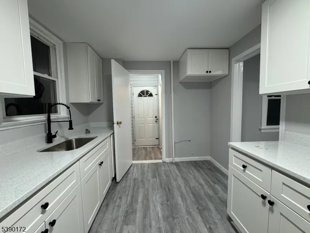 a kitchen with a sink and wooden floor