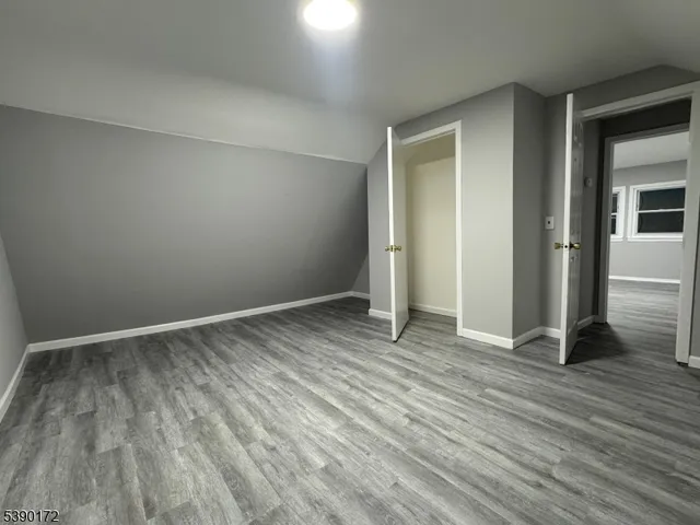 an empty room with wooden floor and closet