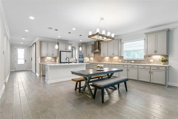 a large kitchen with stainless steel appliances a sink a stove and a refrigerator