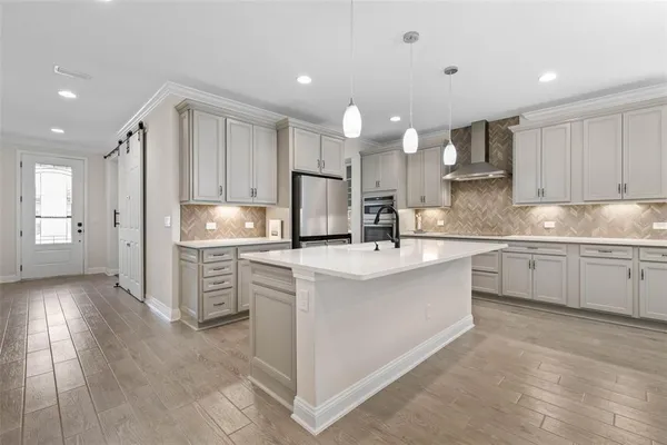 a kitchen with kitchen island granite countertop a sink cabinets and refrigerator
