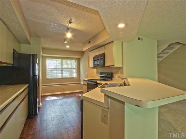 7618 Falcon Rest Circle, Unit 7618 Raleigh, NC 27615 - Photo 6 of 20 a kitchen that has a sink a stove and chairs