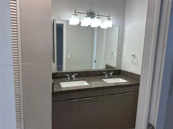 a bathroom with a granite countertop sink and a mirror