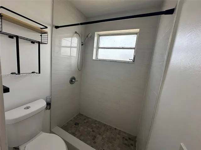 a bathroom with a toilet and a shower