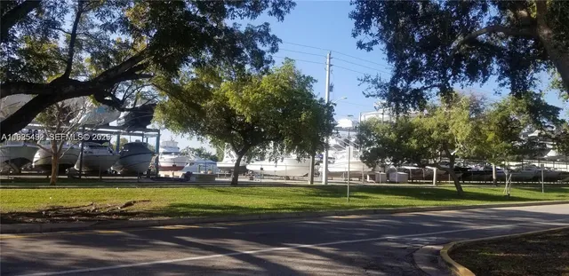 a view of a tennis ground with large trees