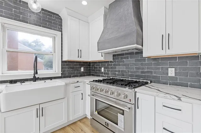 a kitchen with granite countertop white cabinets and white appliances