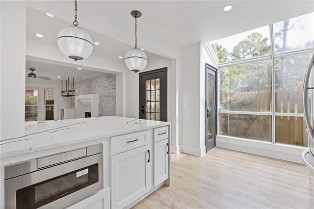 a open kitchen view with granite countertop a stove and a chandelier