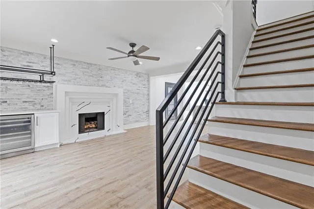 a view of an empty room with wooden floor fireplace and a window
