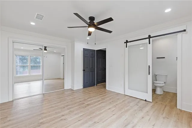 a view of empty room with wooden floor and a ceiling fan
