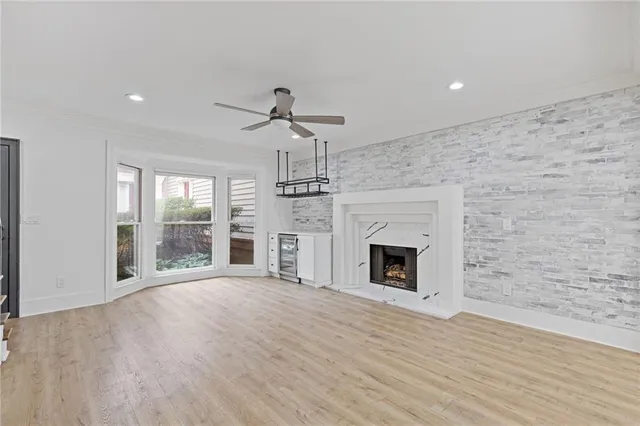 a view of a livingroom with a fireplace a chandelier and wooden floor