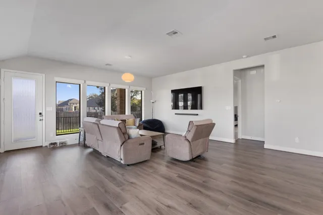 a living room with furniture and wooden floor