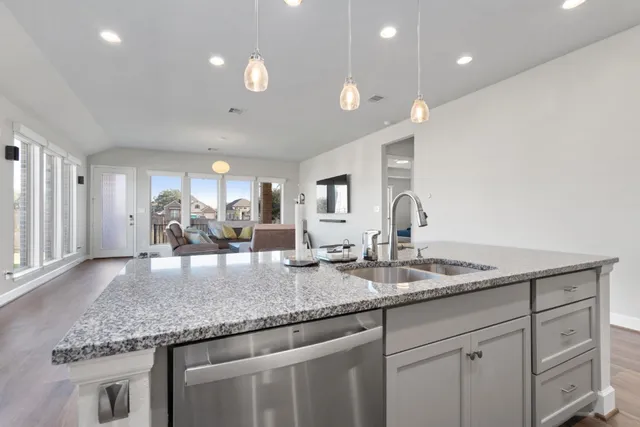 a kitchen with granite countertop kitchen island a sink appliances and a counter space