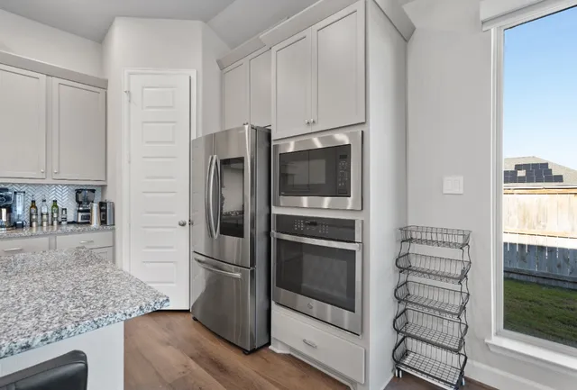 a kitchen with granite countertop a refrigerator and a sink