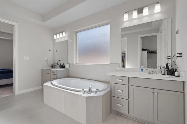 a bathroom with a tub sink and mirror
