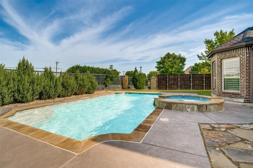 1461 Ramsbury Lane Prosper, TX 75078 - Photo 26 of 30 Resort-style backyard featuring a rectangular swimming pool with stone coping, an integrated hot tub with stone surround, and concrete decking