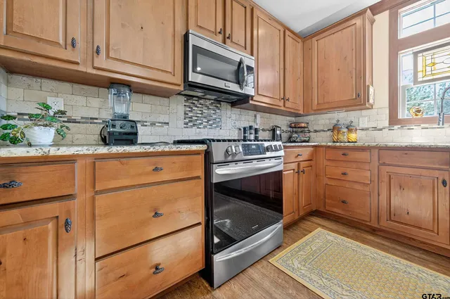 a kitchen with granite countertop cabinets stainless steel appliances and a sink