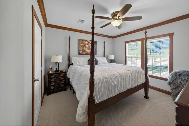 a bedroom with a bed chandelier and a window