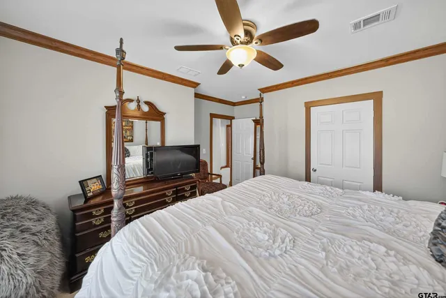a bedroom with a bed and a flat tv screen on a dresser