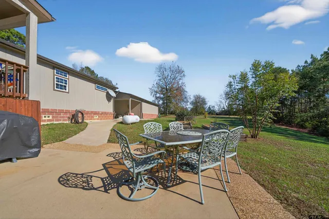 a view of a patio with table and chairs potted plants with wooden fence