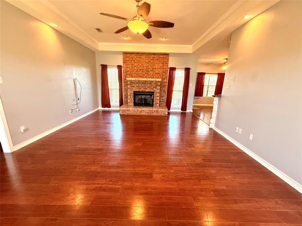 2429 Pecan Springs Road Cleburne, TX 76031 - Photo 12 of 21 an empty room with wooden floor fireplace and windows