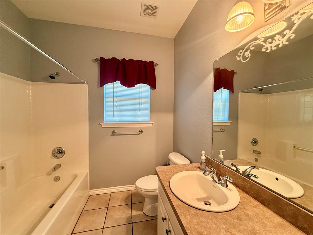 2429 Pecan Springs Road Cleburne, TX 76031 - Photo 8 of 21 a bathroom with a sink a toilet and shower