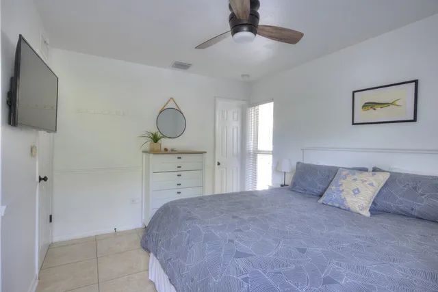 a bedroom with a bed and a flat tv screen on the wall