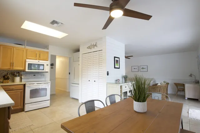a kitchen with stainless steel appliances granite countertop a dining table chairs and granite counter tops
