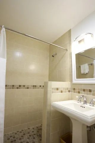 a bathroom with a sink shower and a mirror