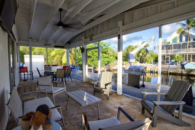 a living room with patio furniture and a floor to ceiling window