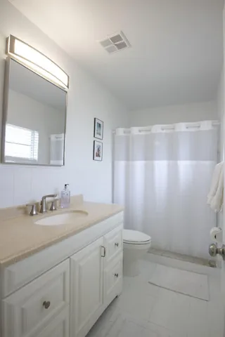 a bathroom with a double vanity sink toilet and a mirror