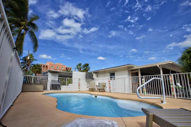 a view of a house with swimming pool and sitting area