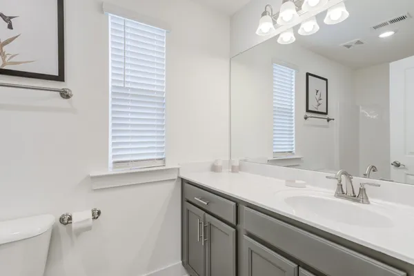 a bathroom with a sink a vanity and a large mirror