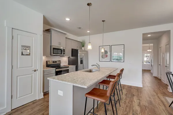 a kitchen with a table chairs refrigerator and microwave