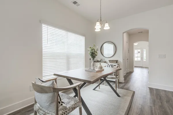 a view of a dining room with furniture and a chandelier