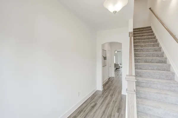 a view of a hallway with wooden floor and staircase