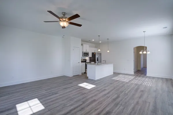 a living room with hard wood flooring and a ceiling fan