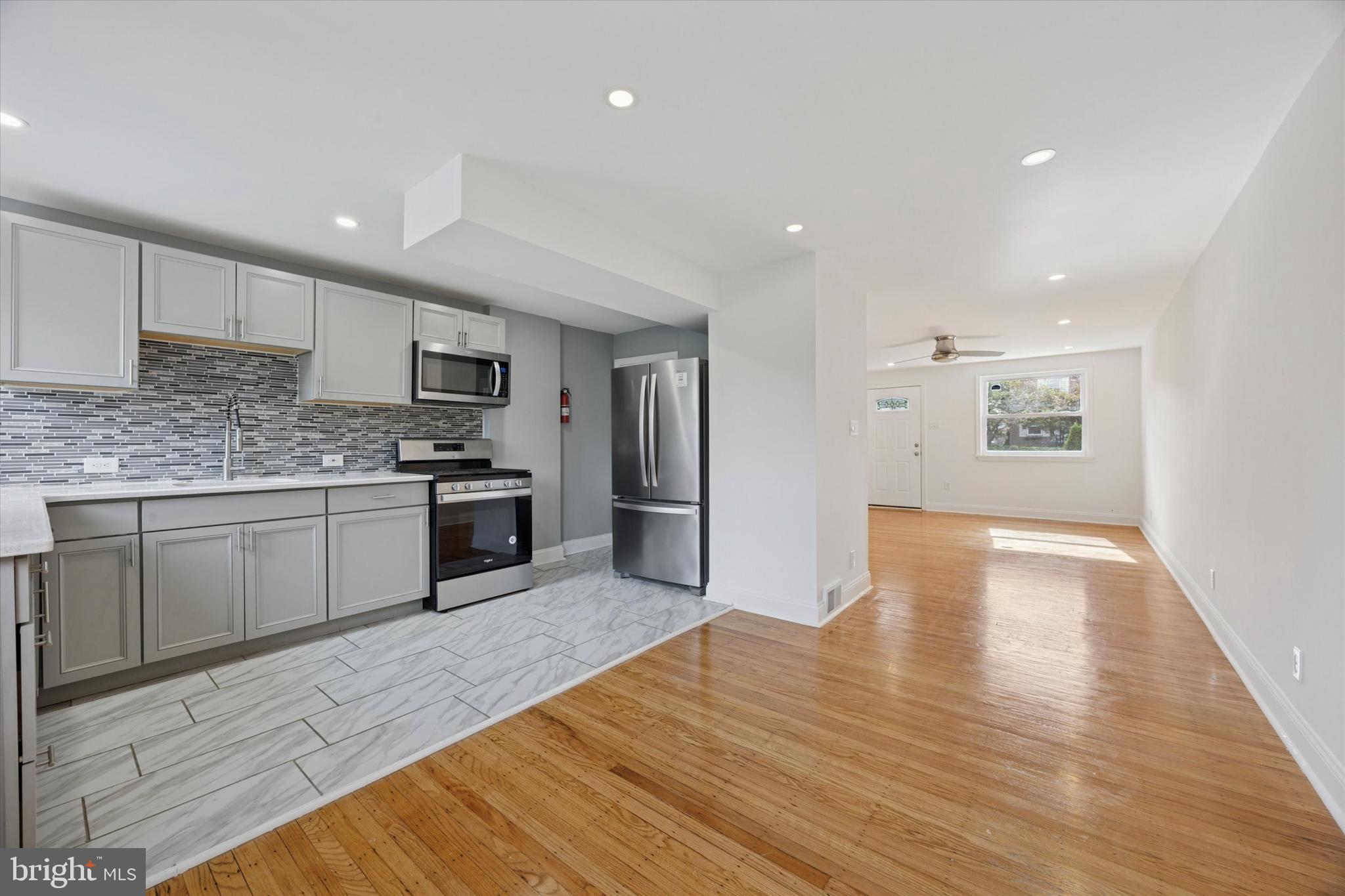 2006 Carter Road Folcroft, PA 19032 - Photo 2 of 25 a large kitchen with a wooden floor a stove a sink and a refrigerator