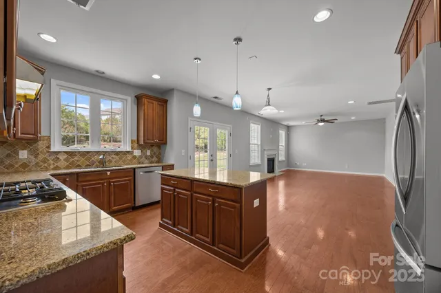 a kitchen with stainless steel appliances granite countertop a sink stove and refrigerator