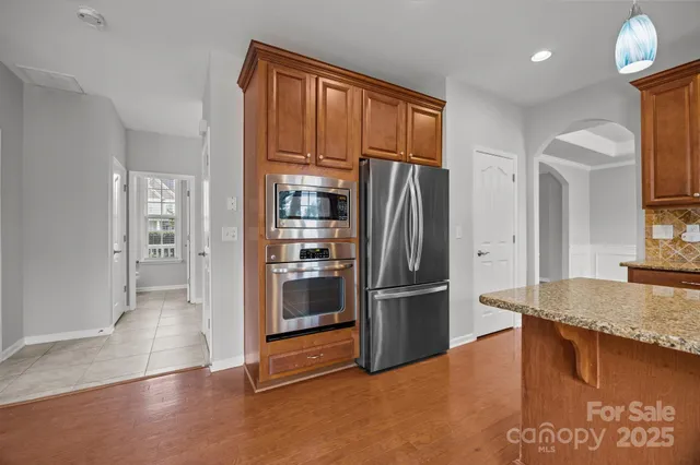 a kitchen with stainless steel appliances granite countertop a refrigerator and a sink