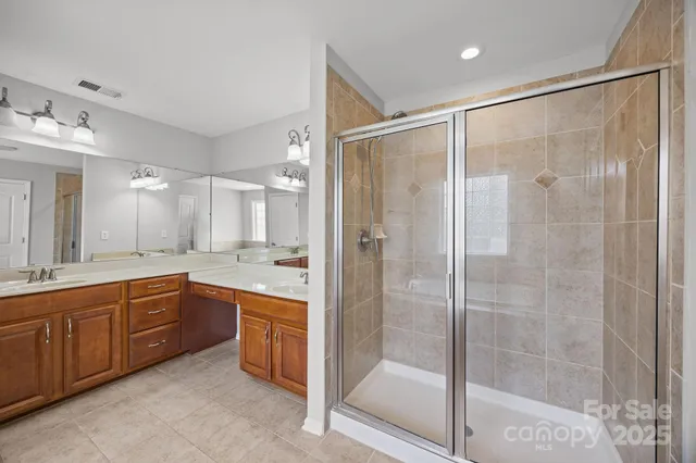 a spacious bathroom with a shower sink vanity and mirror