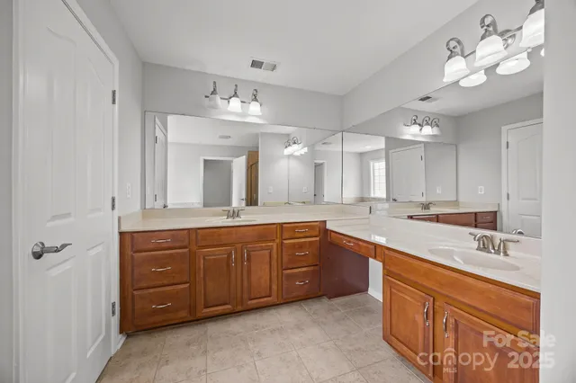 a spacious bathroom with a granite countertop double vanity sink mirror and