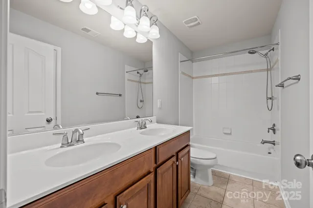 a bathroom with a sink a toilet a mirror a bathtub and shower