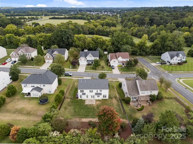 an aerial view of a house with a yard and lake view