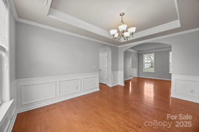 a view of an empty room with chandelier and a window