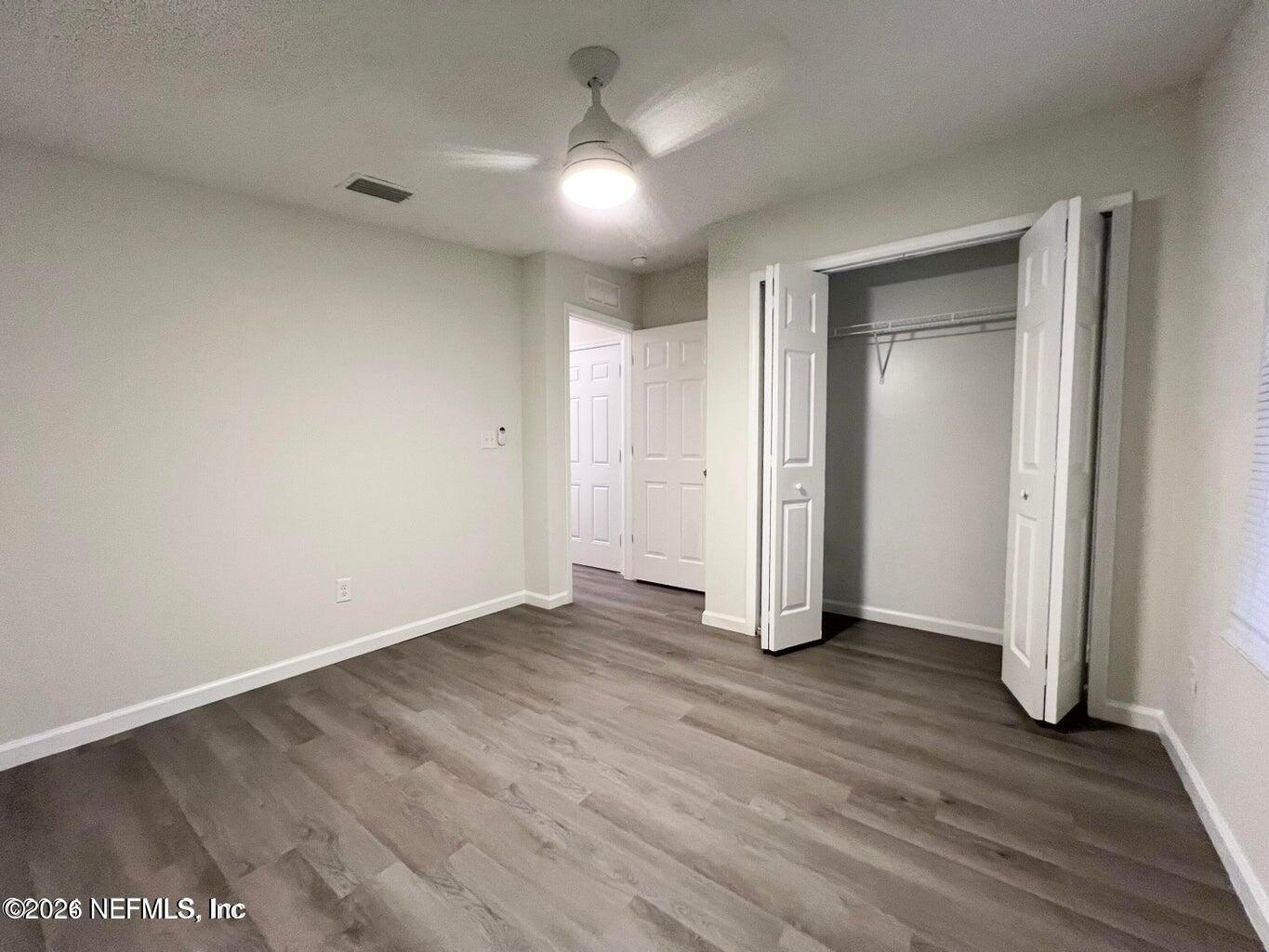 1961 New Haven Road Jacksonville, FL 32211 - Photo 16 of 53 an empty room with wooden floor and a ceiling fan