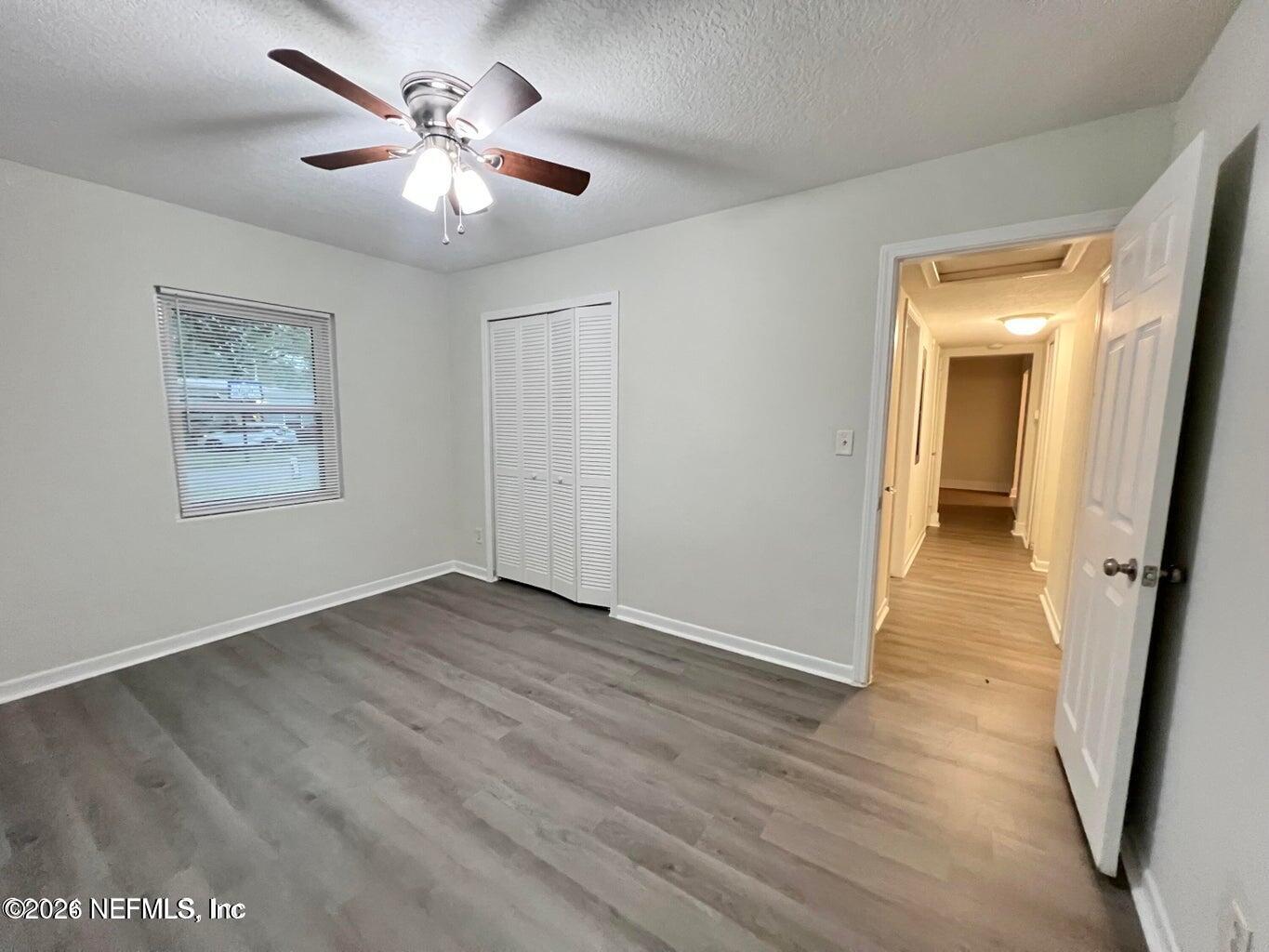 1961 New Haven Road Jacksonville, FL 32211 - Photo 39 of 53 an empty room with wooden floor and a ceiling fan