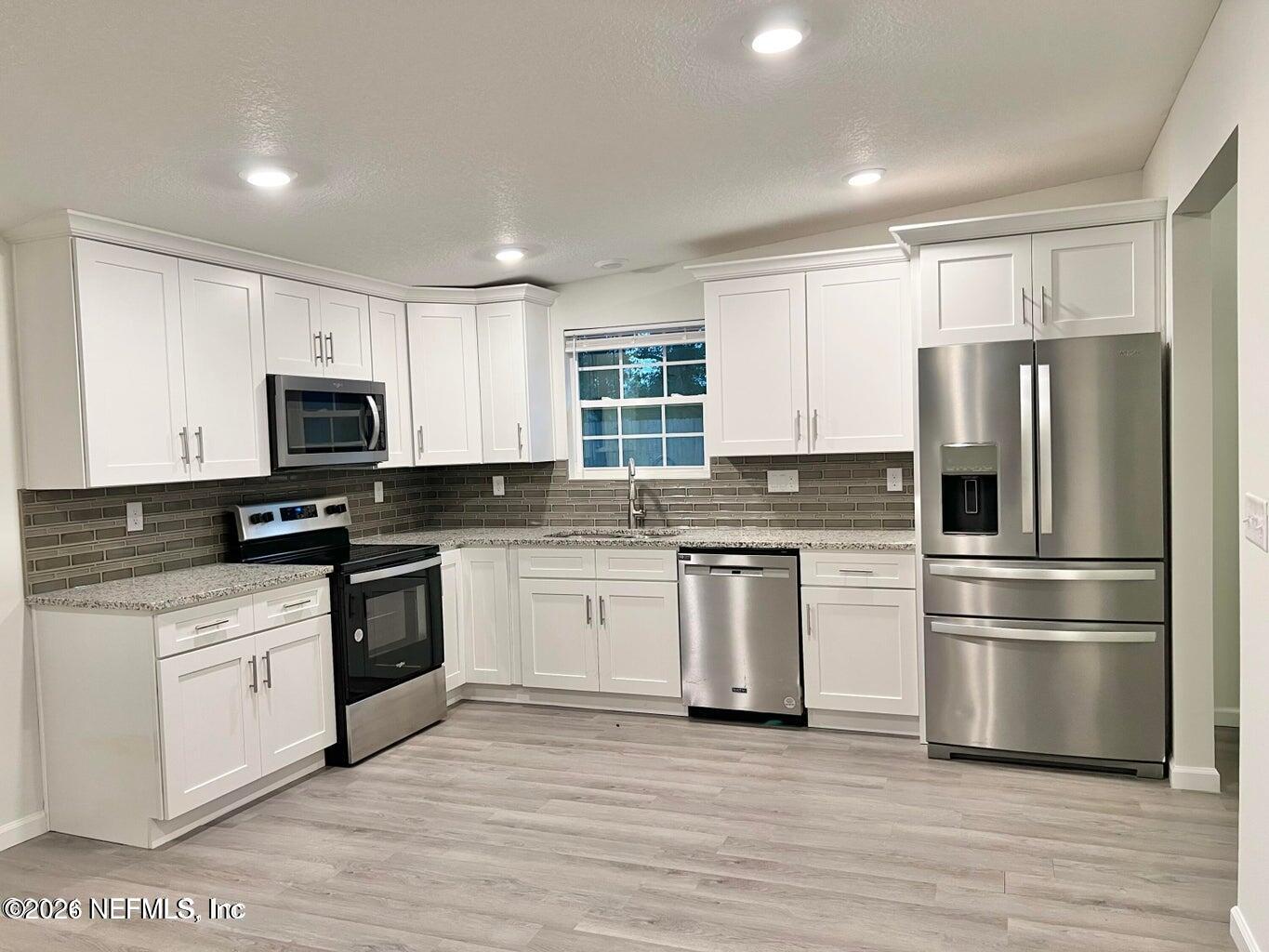 1961 New Haven Road Jacksonville, FL 32211 - Photo 7 of 53 a kitchen with granite countertop a refrigerator stove and microwave