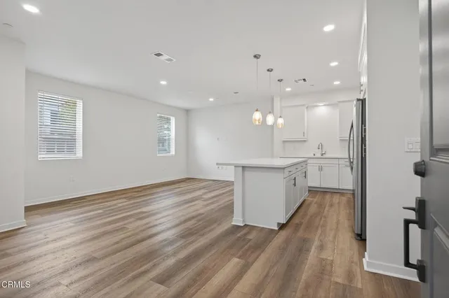 a view of large kitchen with wooden floor and windows